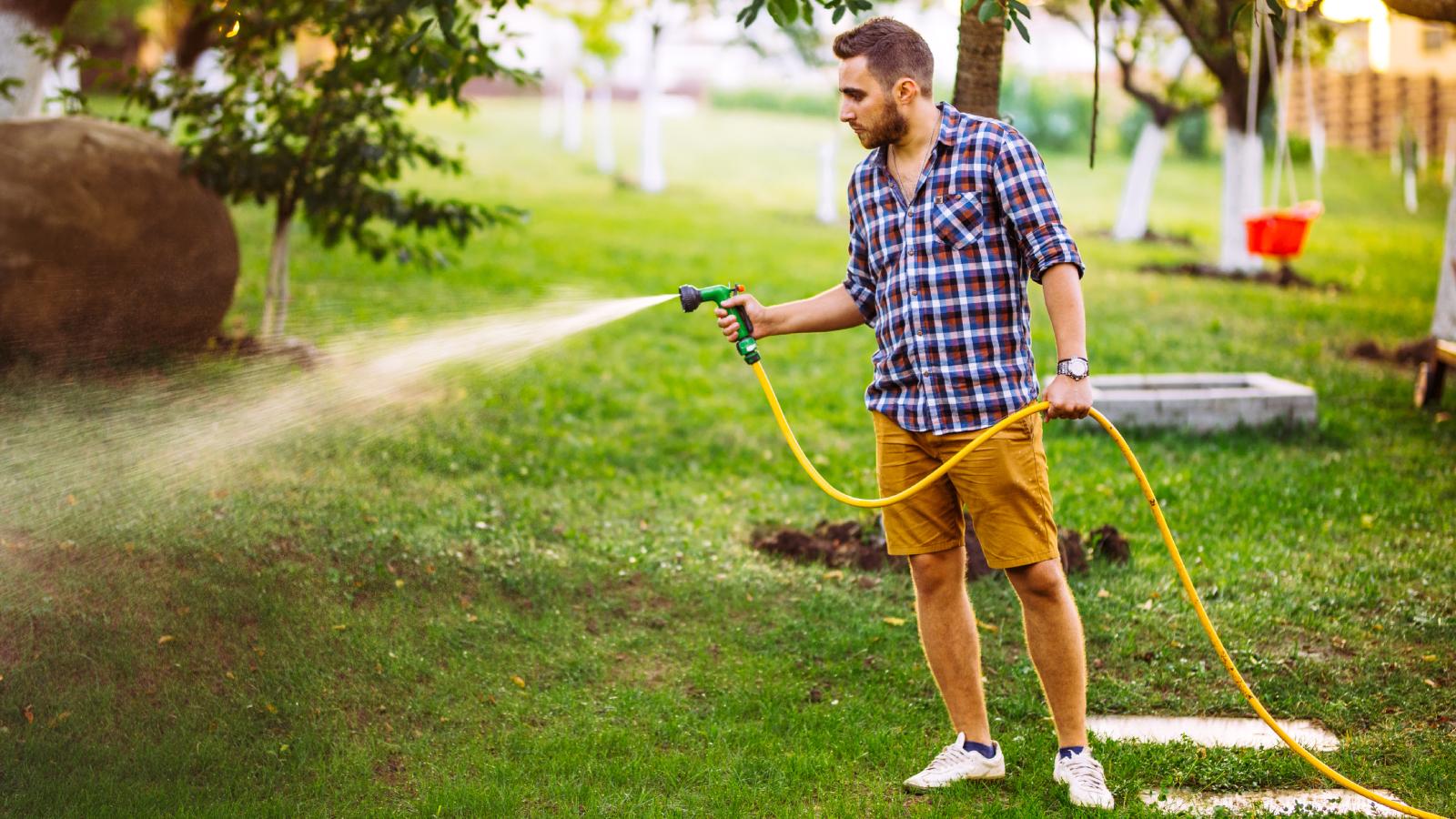 His Water Bills Were Suddenly Astronomical. The Stealthy Way His Neighbor Was Stealing From Him Is Mind Blowing. man watering his lawn