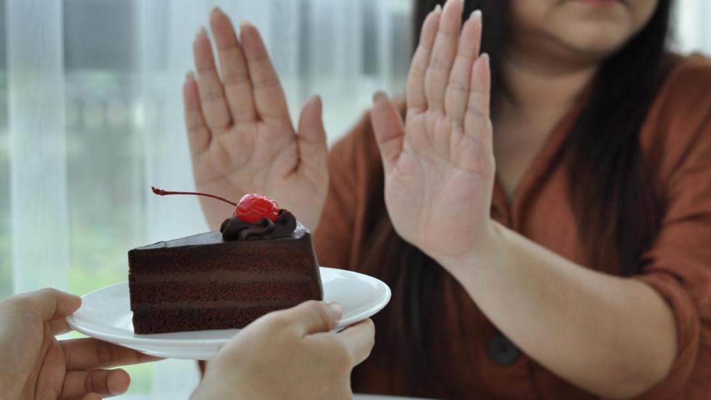 woman refusing a piece of cake