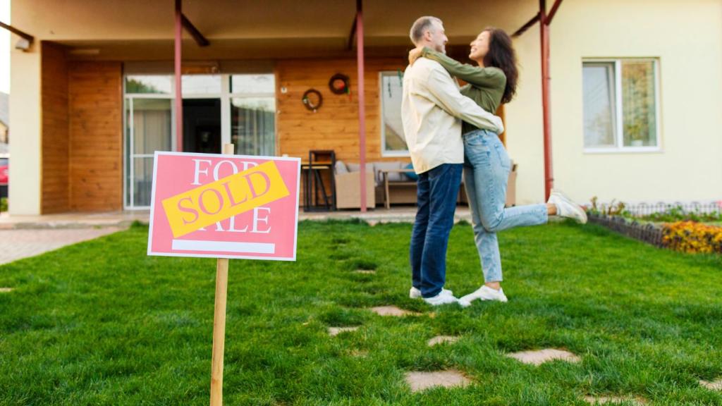 couple in front of a sold house
