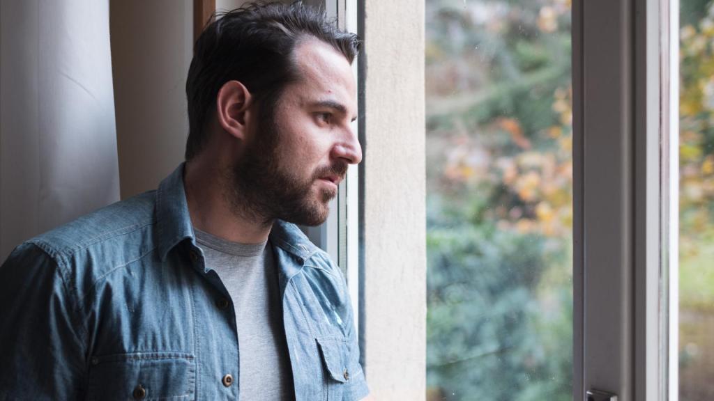 man looking out a window