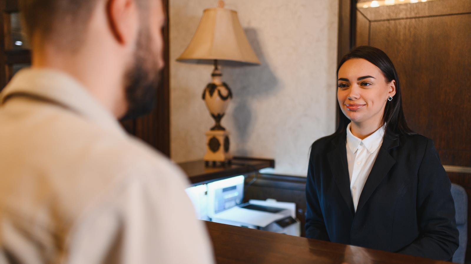 Why Do I Have to Pay?: Hotel Guest Outraged After Front Desk Breaks News on Room Switch Fee hotel worker talking to a guest