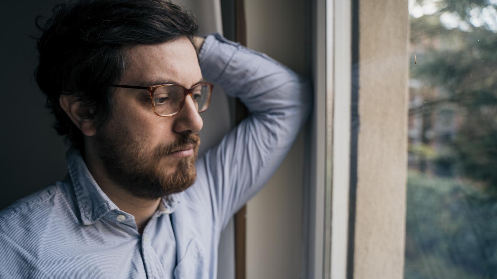 They Recorded Their Noisy Neighbors—But The Evidence Only Escalated The Feud man looking out a window