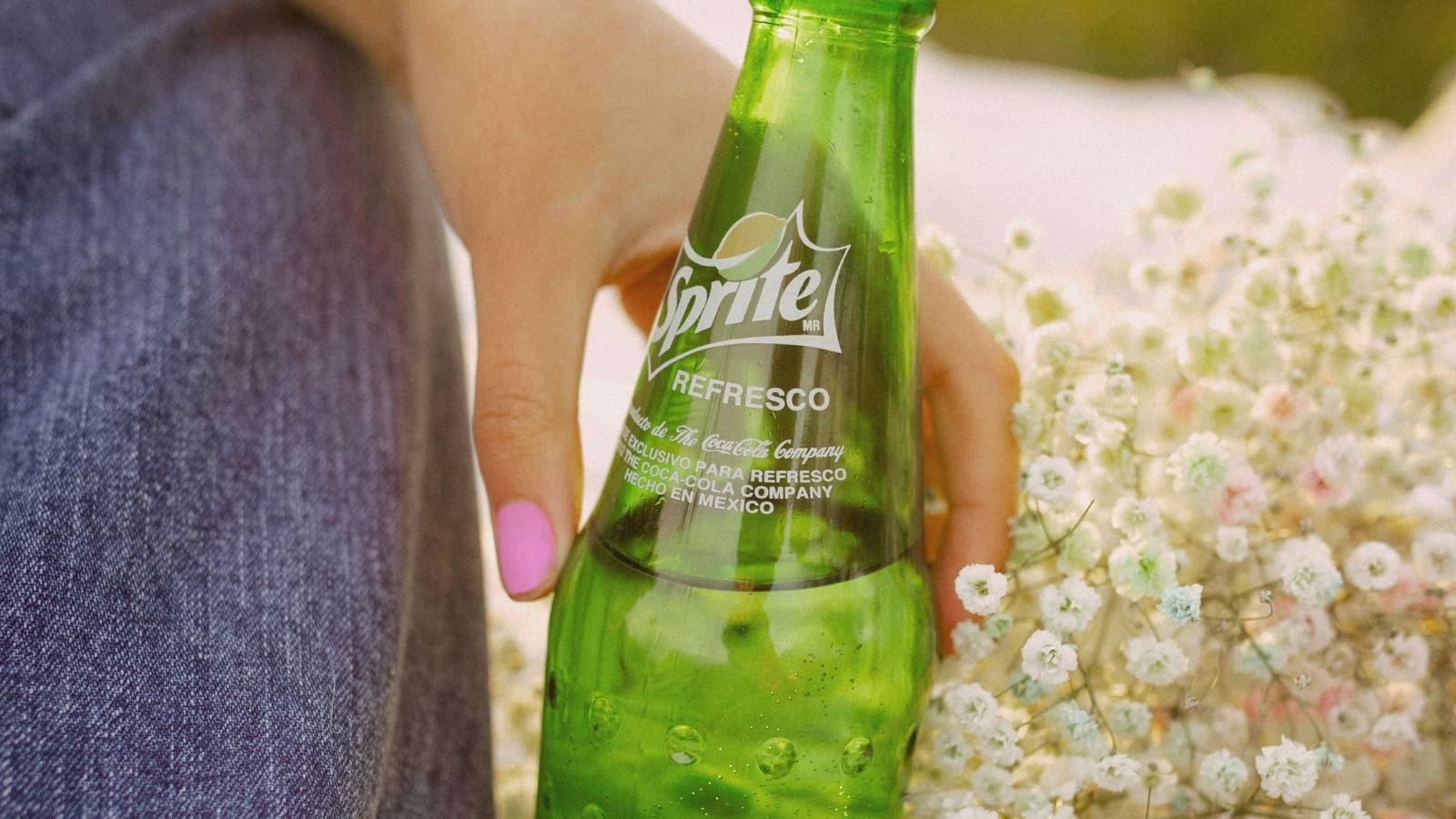person holding a bottle of sprite