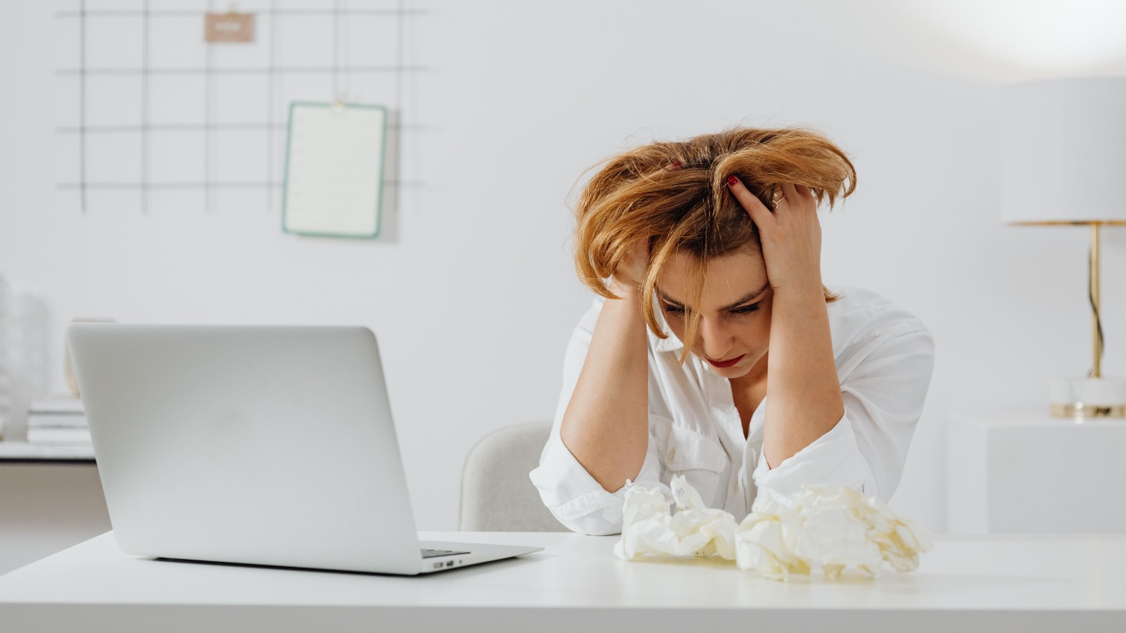 Her Manager Treats Her Feedback Differently From Everyone Else on the Team — And Not in a Good Way a stressed woman, holding her hair and looking down