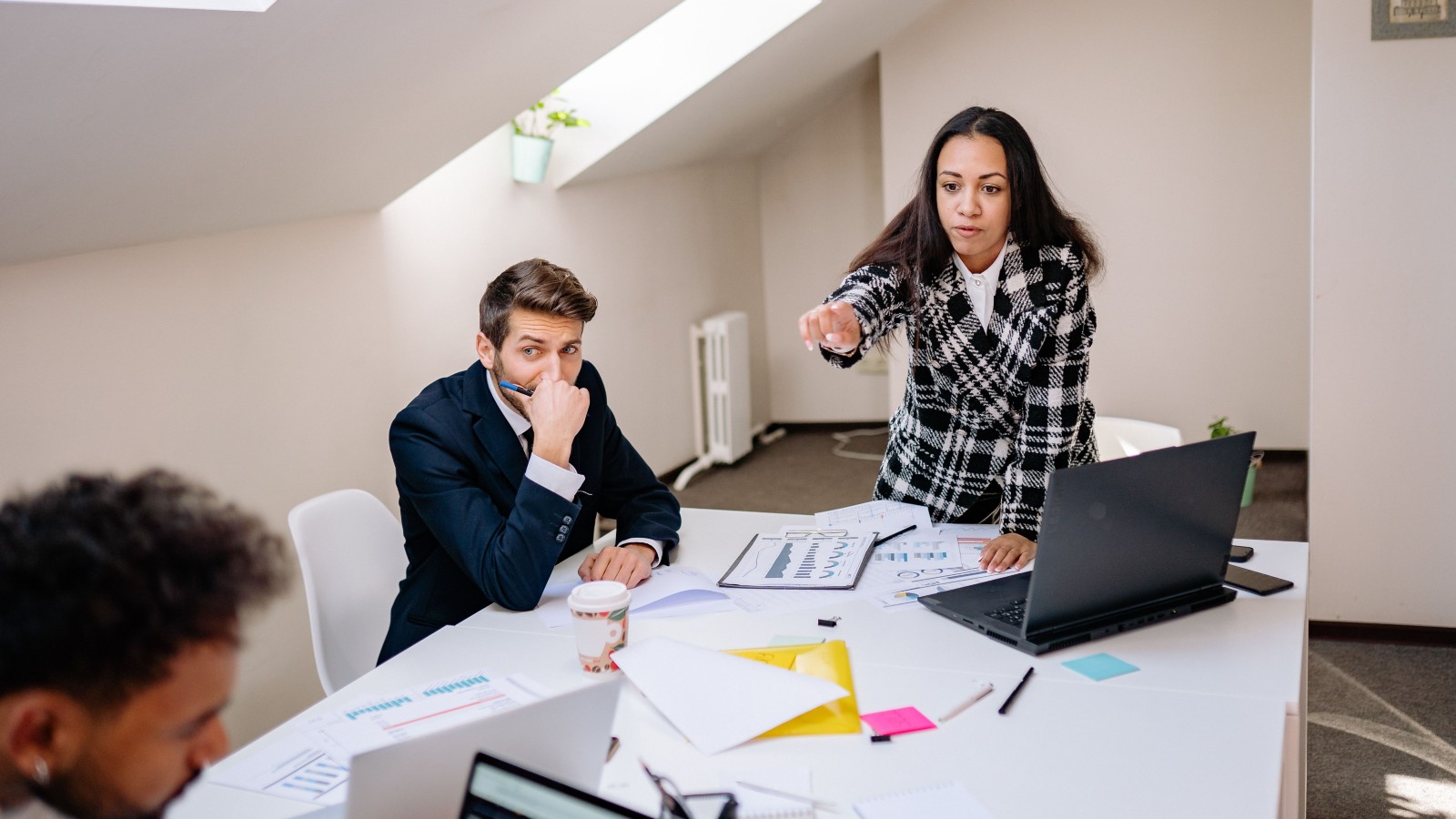 a woman pointing at a man in a meeting