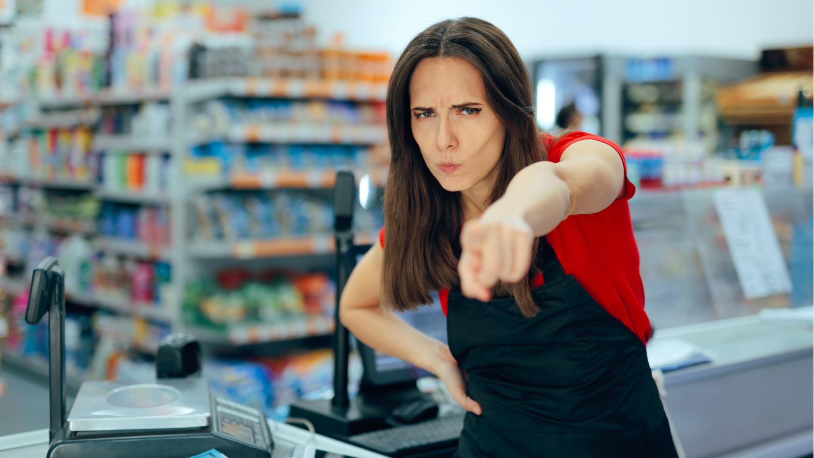 A cashier points at someone in anger