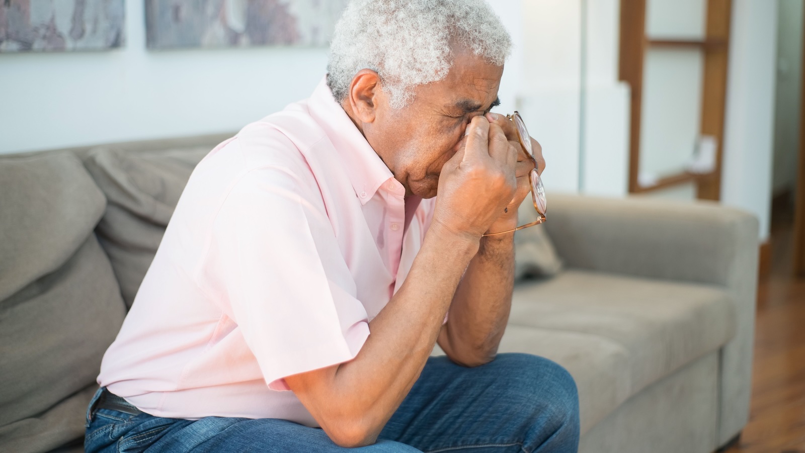 She Needed Comfort After a Brutal Breakup. Instead, Her Father Turned Her Trauma Into a Monologue About His Own Life. elderly man blowing his nose on the couch