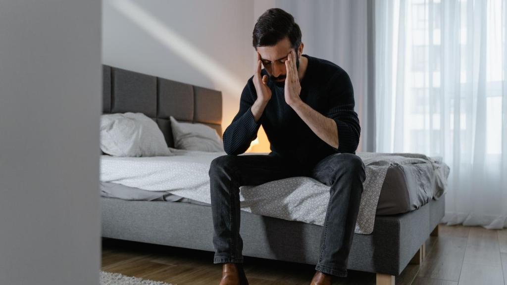 stressed man sitting on his bed