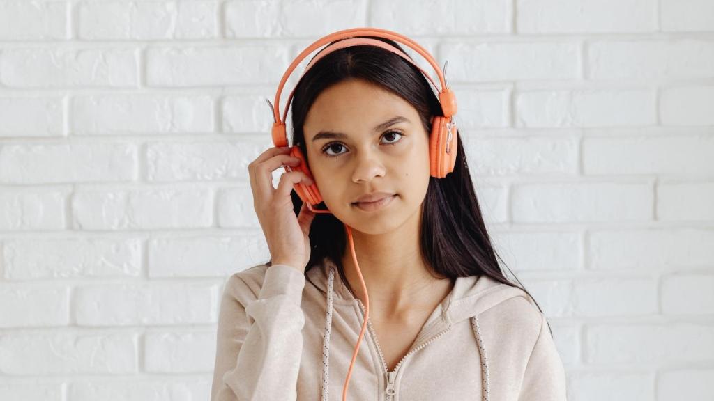 teenage girl wearing orange headphones