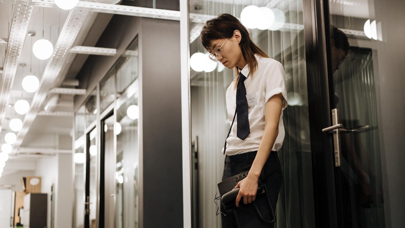 After 12 Months of Her New Boss Cutting Her Off Mid Sentence, a Corporate Employee Reached Full Burnout and Gave Up upset corporate employee standing in hallway