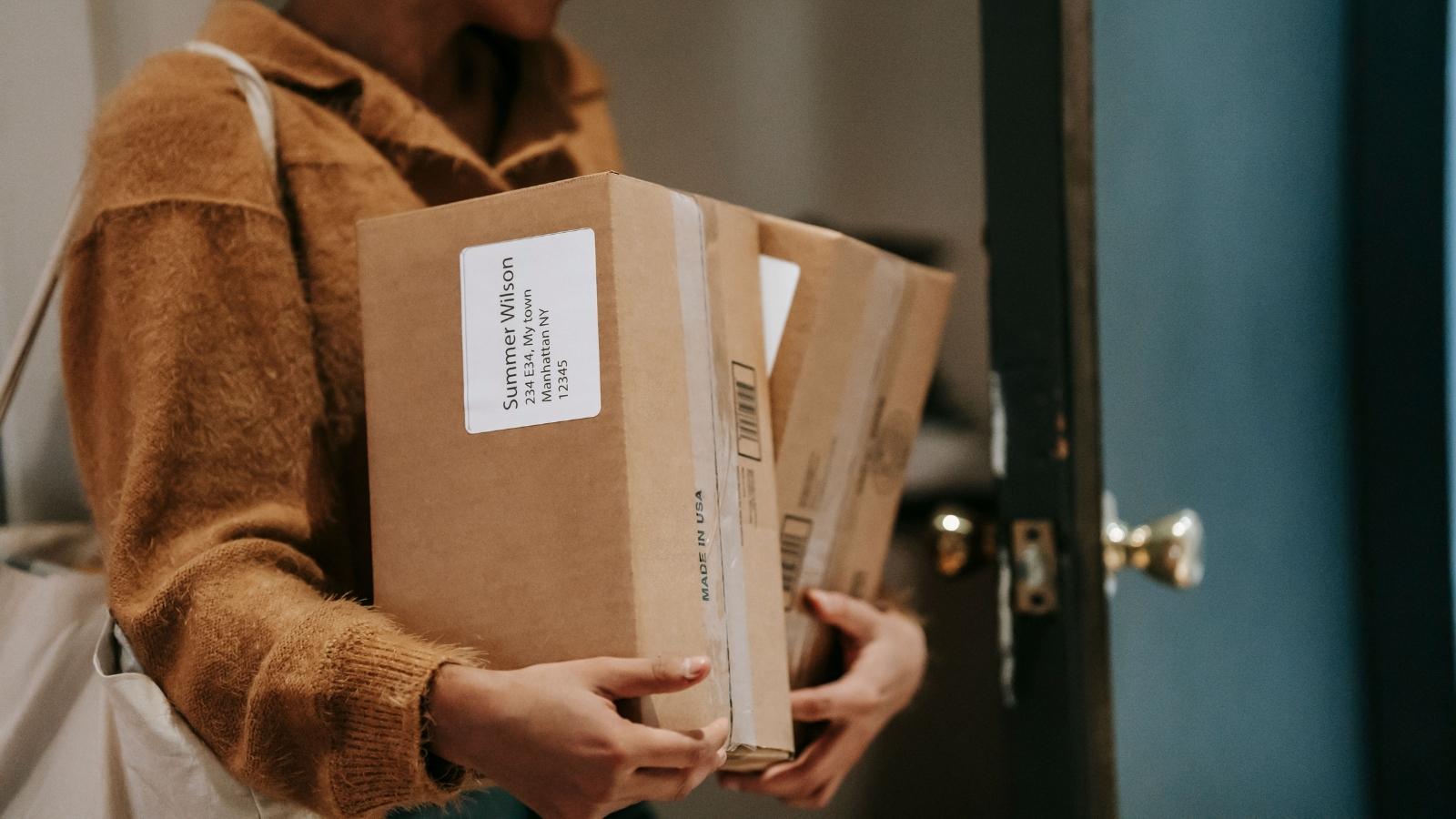 She Offered to Watch Her Neighbors House for Six Weeks — She Didnt Know Her Neighbors Amazon Habit Would Turn It Into a Daily Package Hauling Job woman carrying stack of boxes