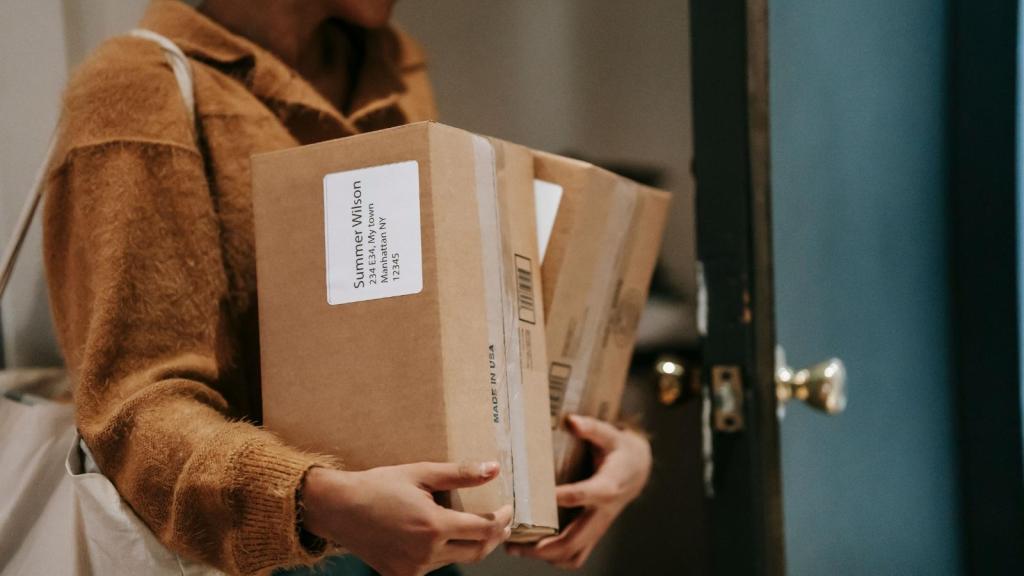 woman carrying stack of boxes