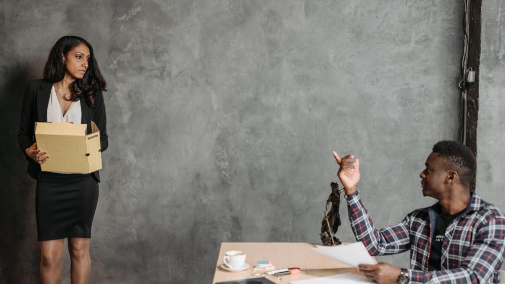 woman getting fired holding box of stuff