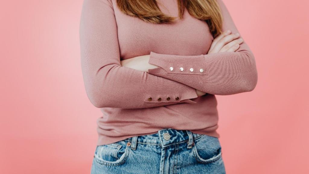 woman in pink shirt crossing her arms