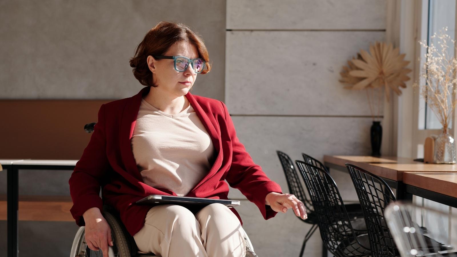 She Accepted Lower Pay and a Demotion to Accommodate Her Disability—Only to Face Complete Hostility From Her Boss woman in red sweater in wheelchair