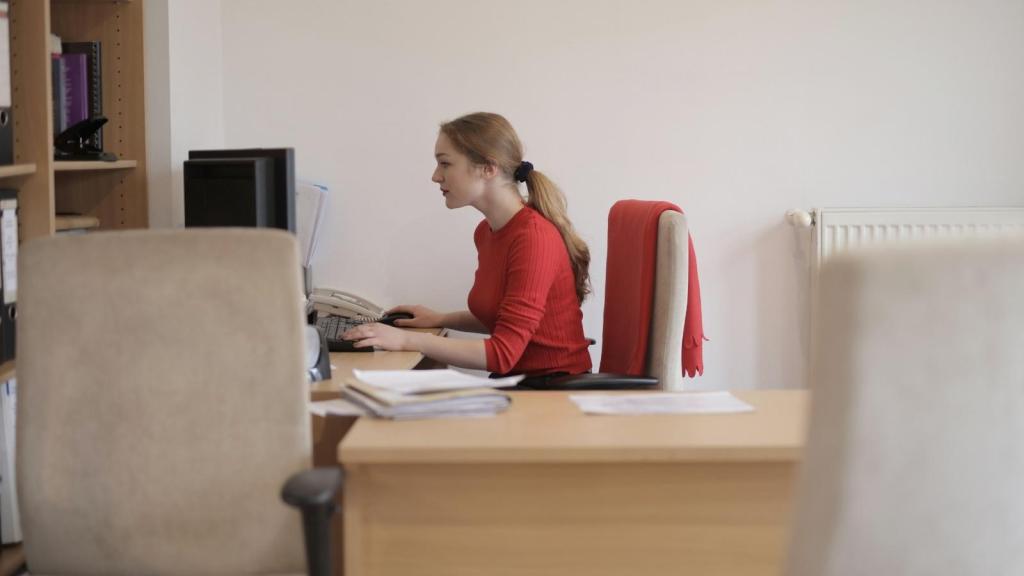 woman in red sweater working at her desk