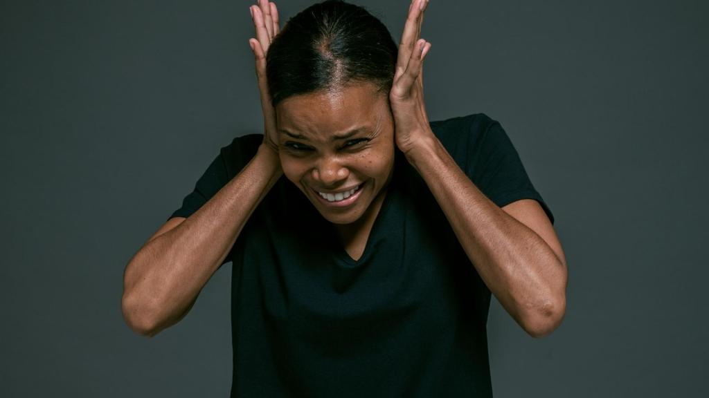 woman in scrubs covering her ears