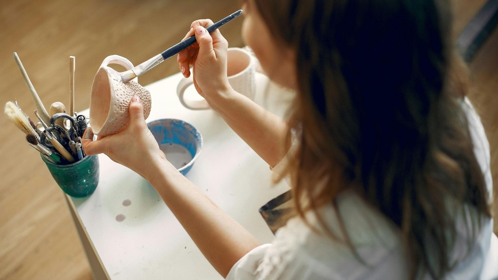 woman painting ceramics