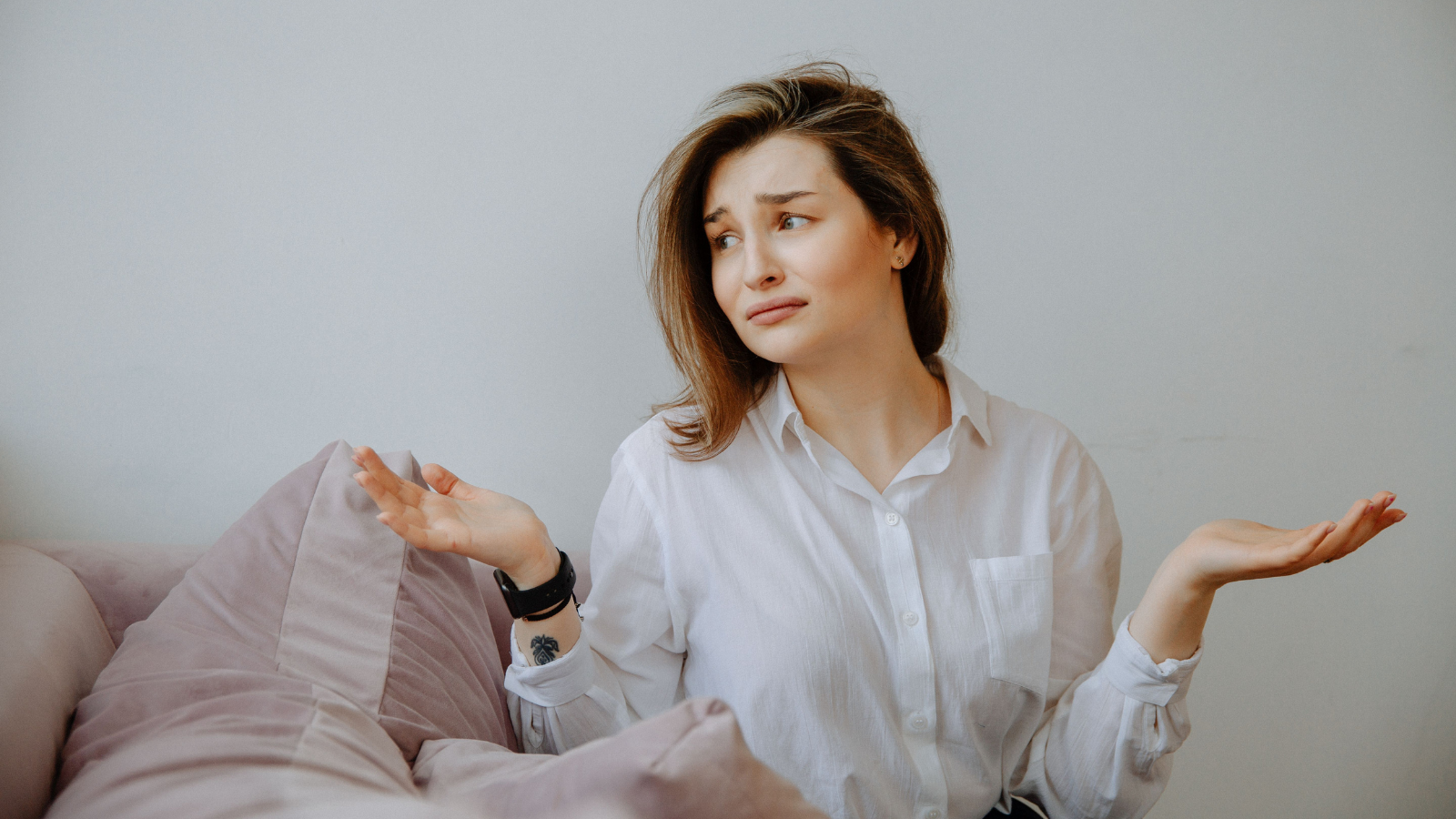 Family Tension Grows After Bride Refuses to Put Her Pregnancy Plans on Hold for Her Sibling woman shrugging on the couch