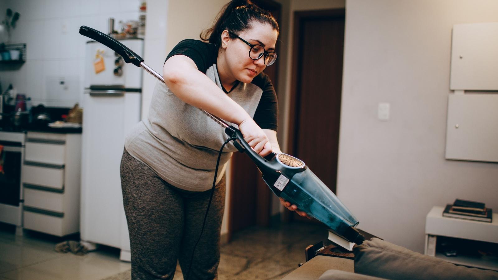 They’re Doing It on Purpose: Resident Realizes Neighbors Loud Habit Has Become a Calculated Daily Warfare woman vacuuming her apartment