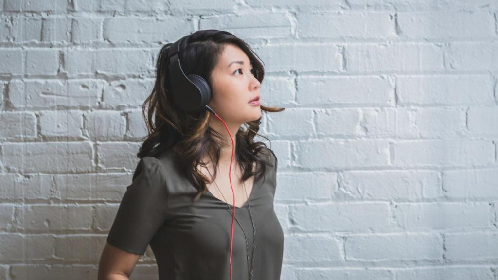 woman wearing headphones in front of brick wall