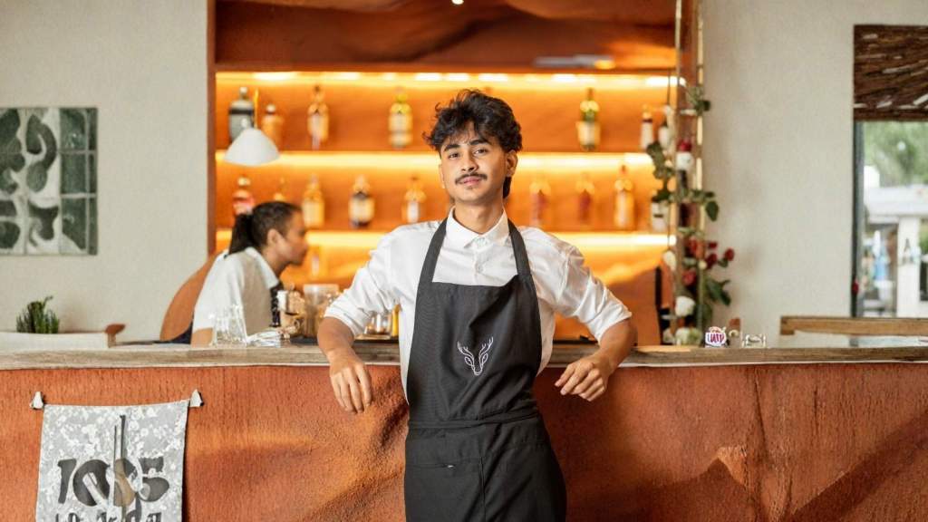 young male restaurant worker wearing an apron