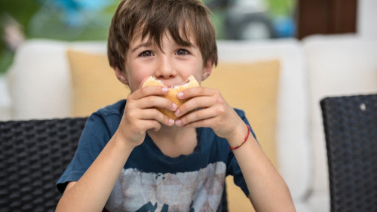 little boy eating a sandwich