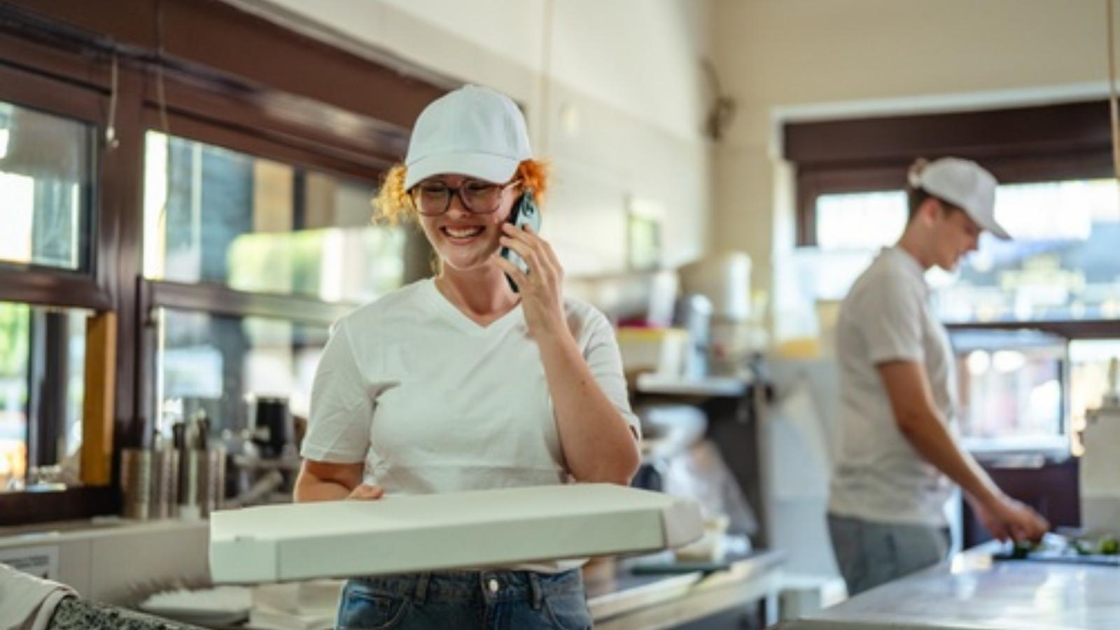 Woman working at a pizza shop.