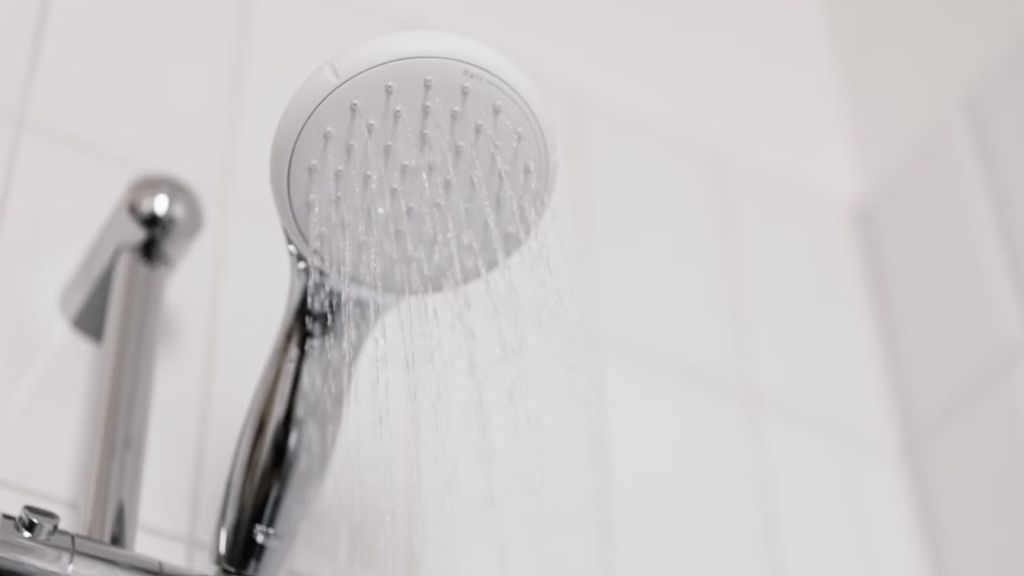 Shower head pouring water inside the bathroom