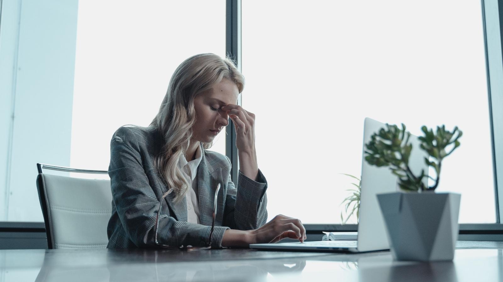 Woman sitting at her desk stressed out