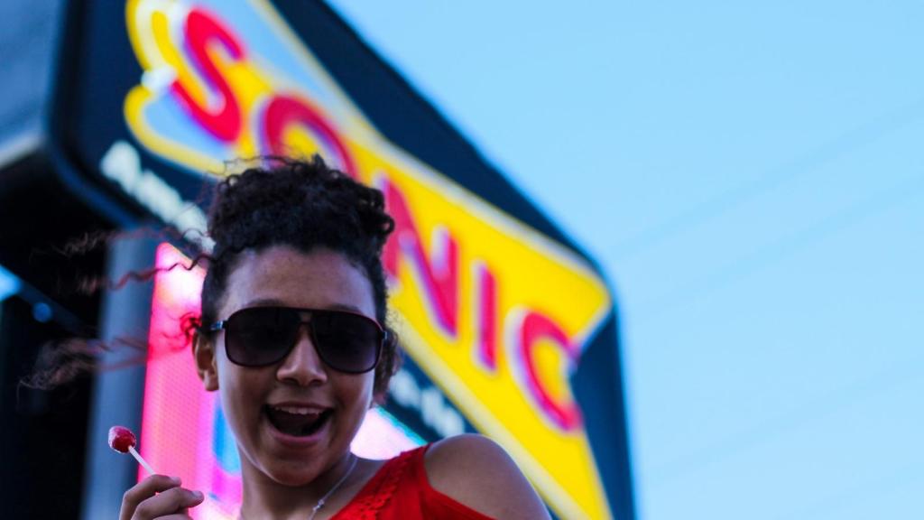 Carhop acting silly under Sonic Sign