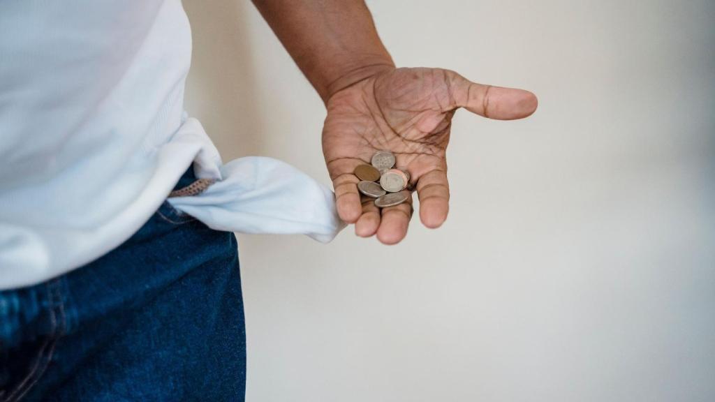 Man pulling change out of his jeans pocket