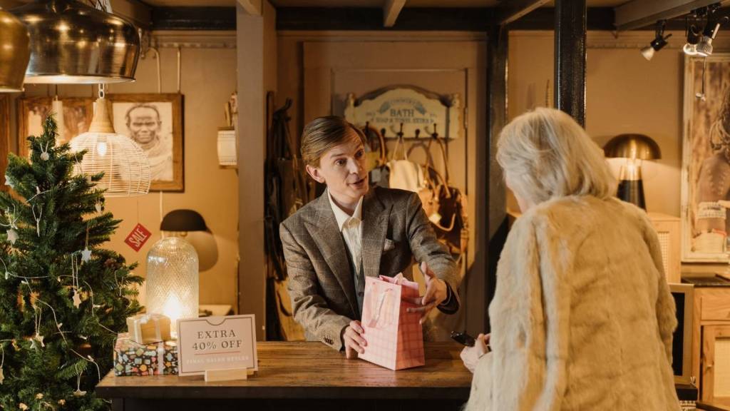 Man handing a customer her bag