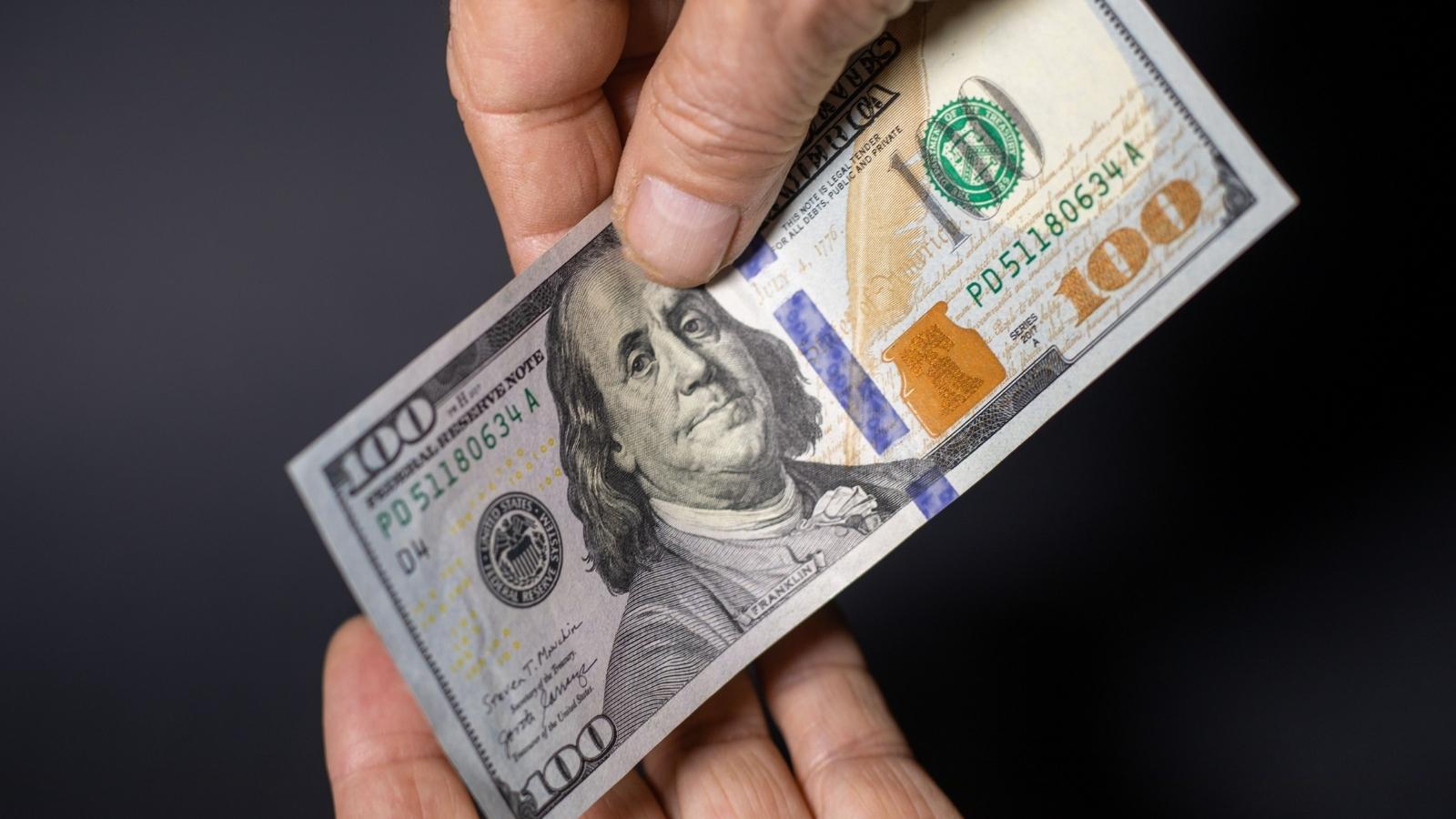 She Tried to Pay for a Small Item With a $100 Bill—Then Threw a Tantrum When the Register Ran Dry Man holding $100 to pay for goods