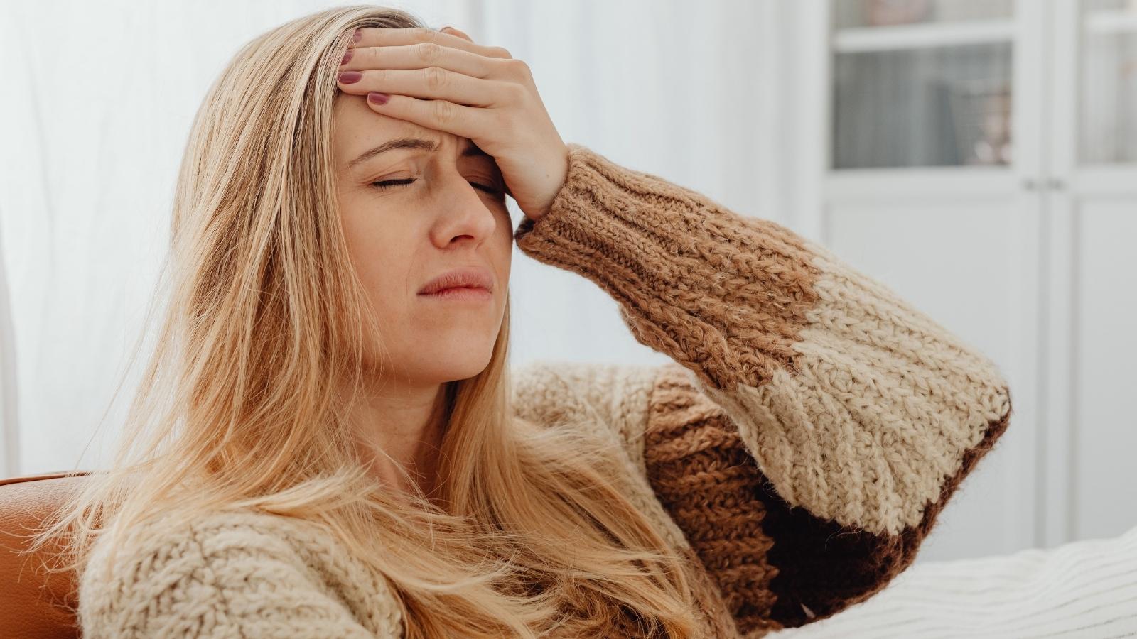 Woman holding her head, unsure of what to do