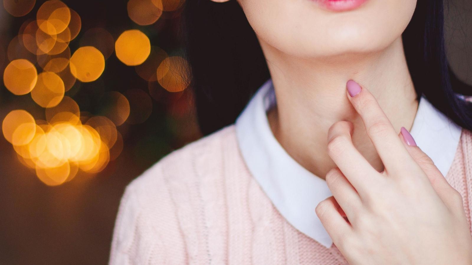 A Cashier Refused to Give Her Water Without 27 Cents—So Another Customer Decided to Step In Woman pointing to her throat