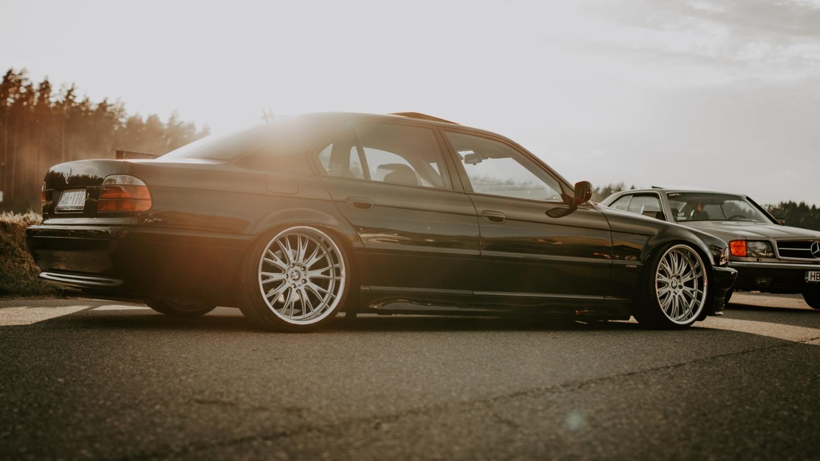 He Asked His Neighbor to Move Her Car So He Could Reach His Parking Spot—But She Told Him to Drive Over the Curb Low rider BMW parked on a flat lot