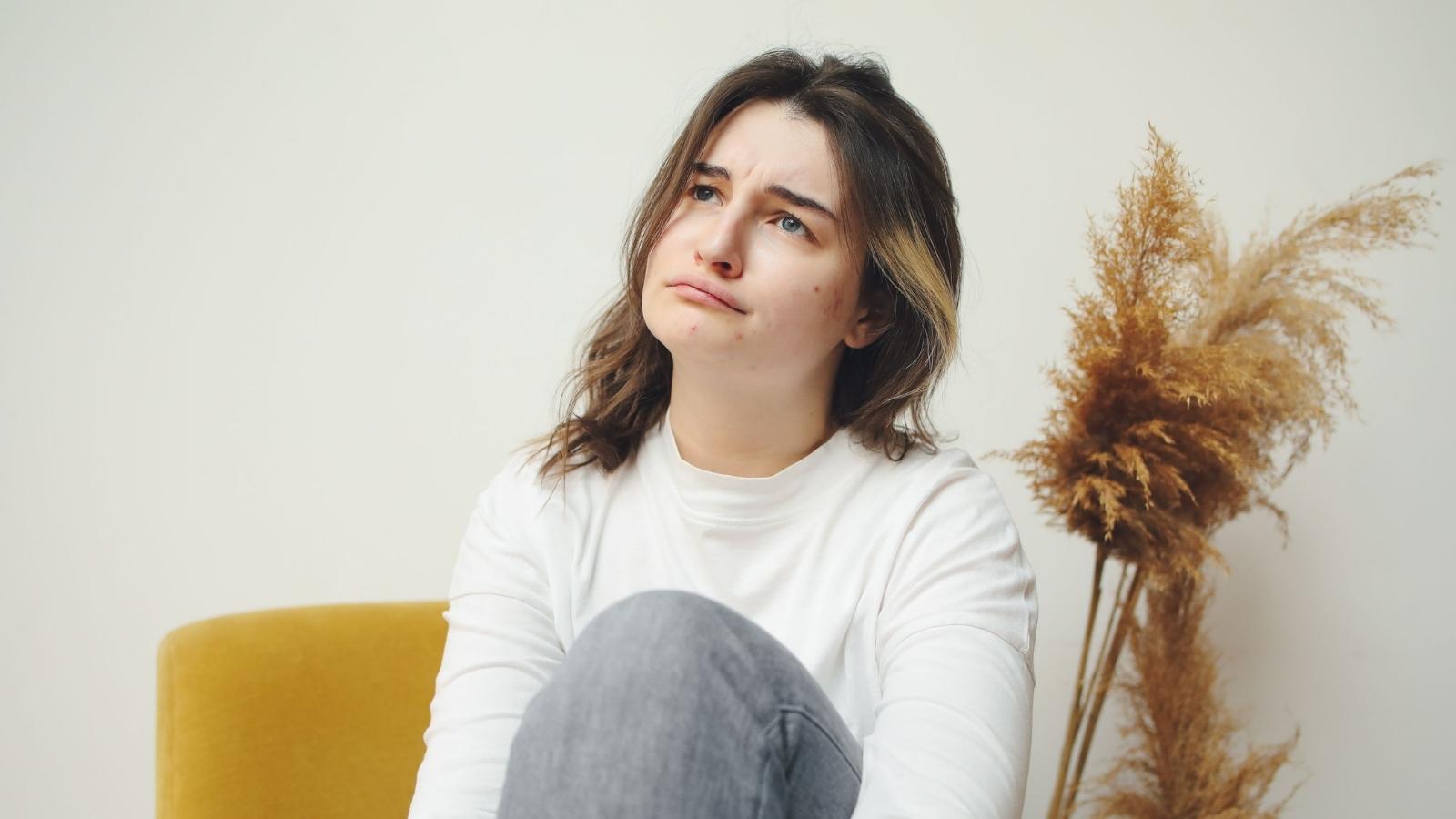They Moved Into a Bigger House Specifically So His Brother Could Live With Them—Now His Constant Mess Has Her Ready to Ask Him to Leave Woman sitting in a chair thinking about kicking out BIL