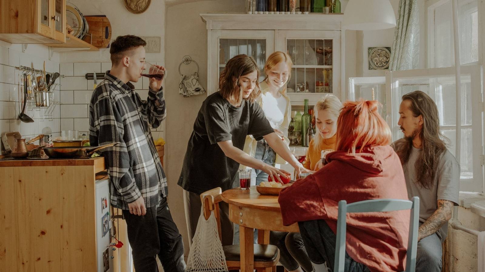 Group of roommates standing around a table. 