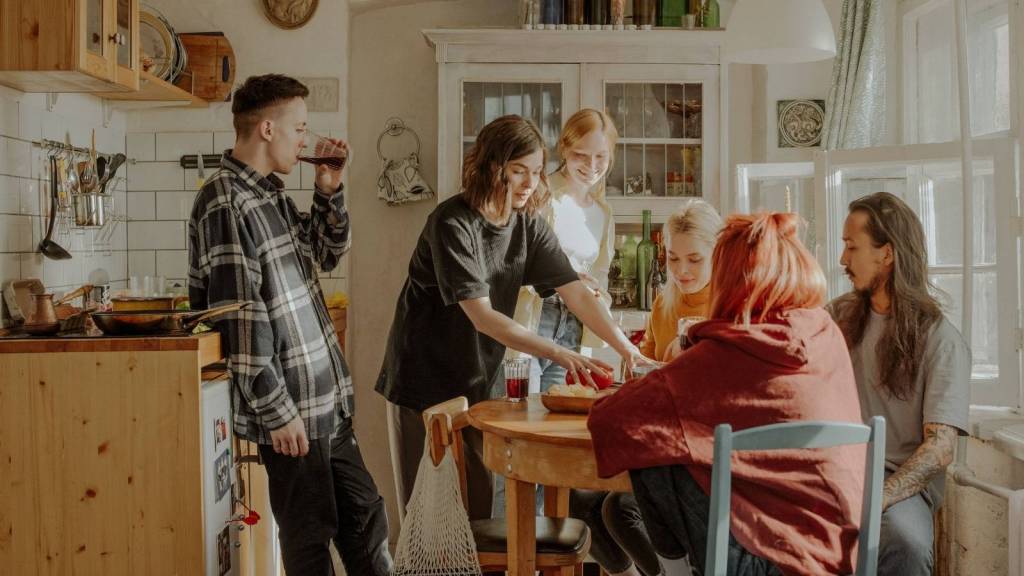 Group of roommates standing around a table.