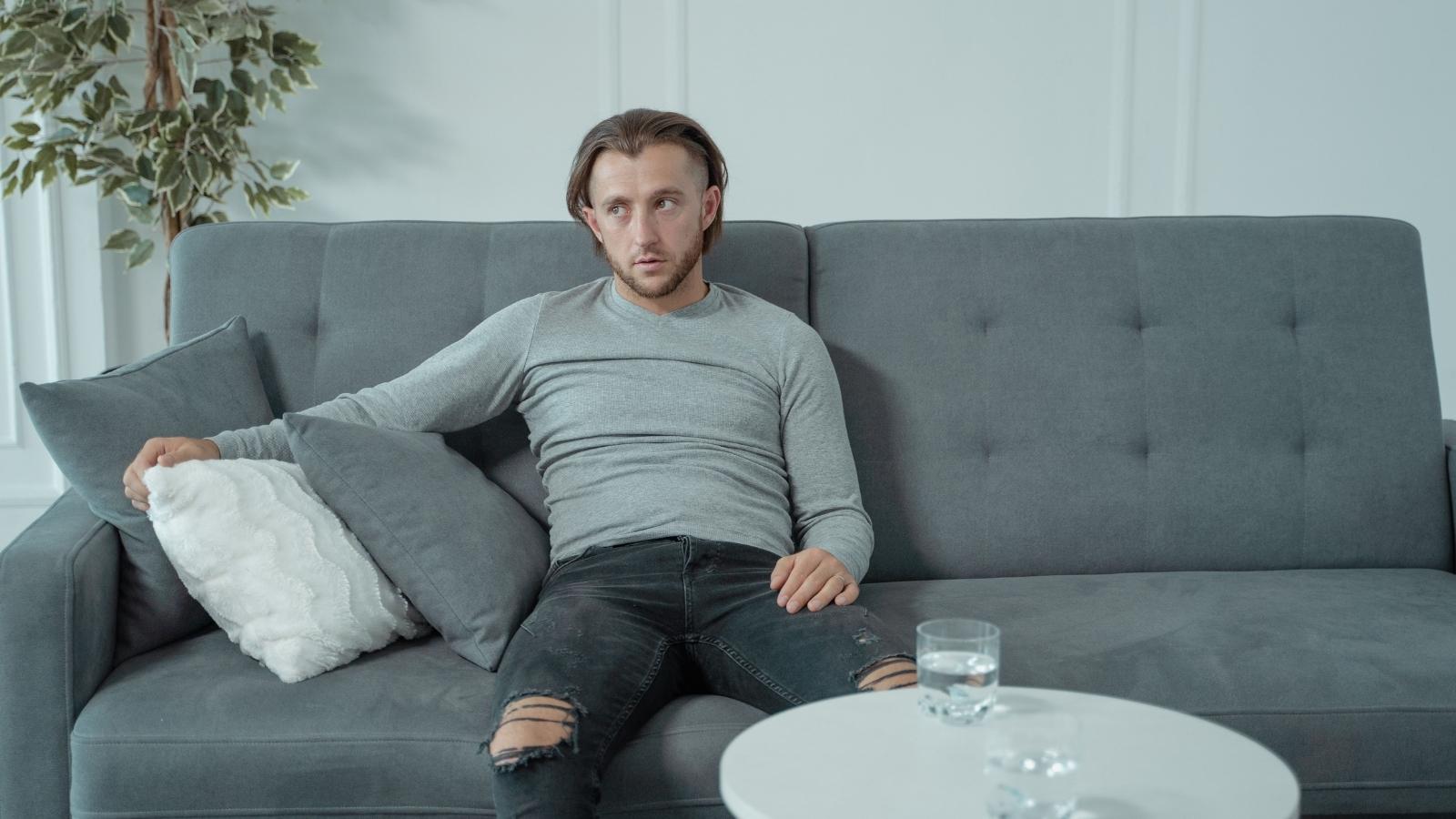 A UK Homeowner Regrets His Purchase After 18 Months of Thin Walls—and the Newest Tenant Is the Loudest Yet Man sitting on his couch, fed up with loud neighbors