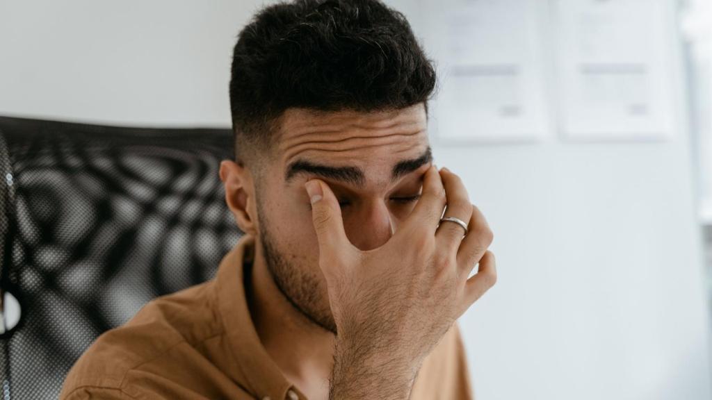 Man rubbing his eyes after getting woken up