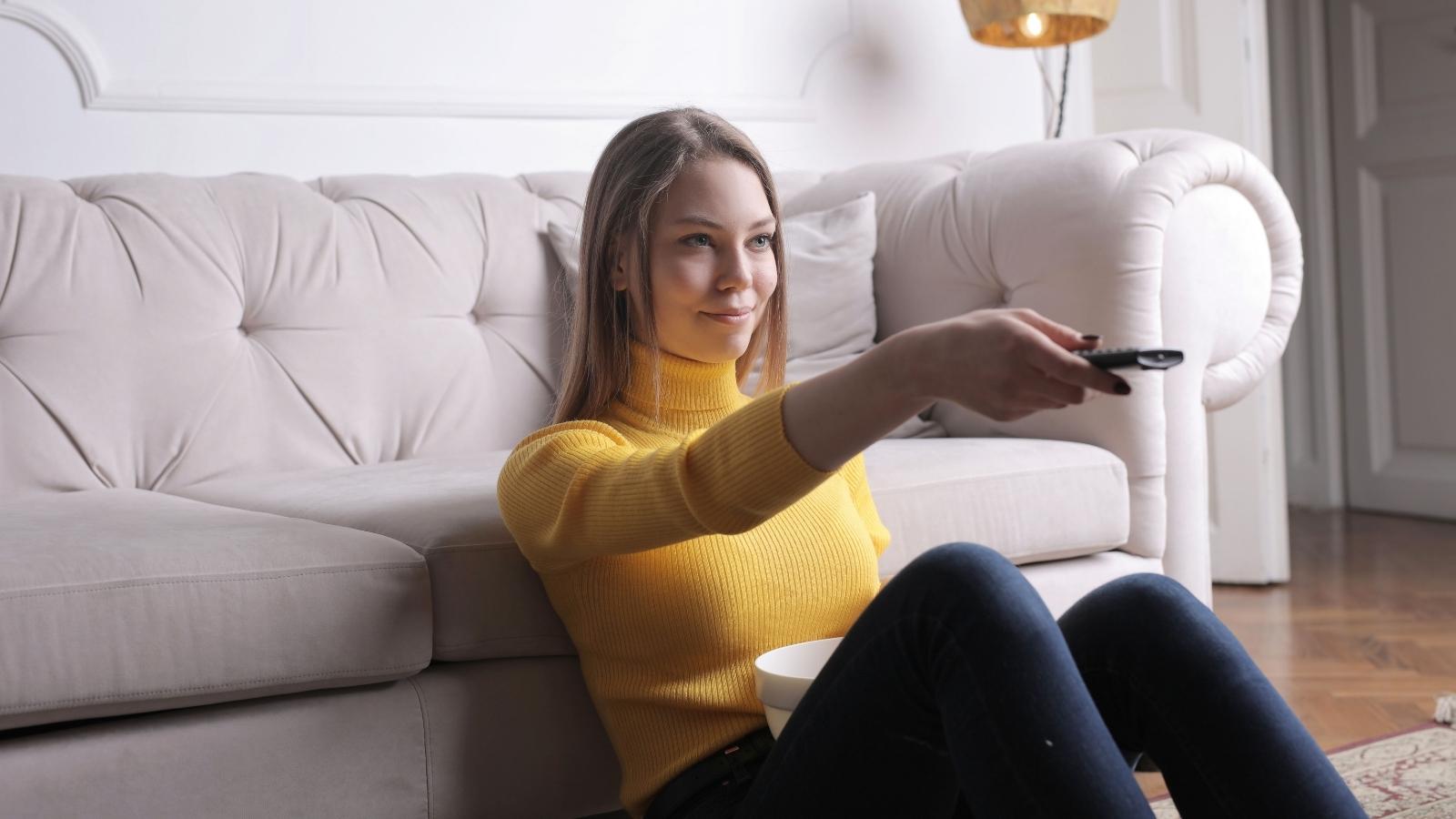 She and Her Dad Bond Easily Over the Same Movies—But Her Mom Quietly Stopped Asking Her to Watch Anything Together, and Now the Guilt Wont Let Up Teen girl putting on a movie to watch with her dad