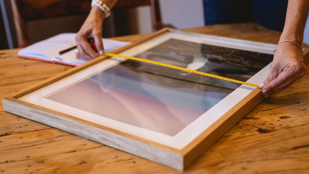 Woman measuring a photo for a frame