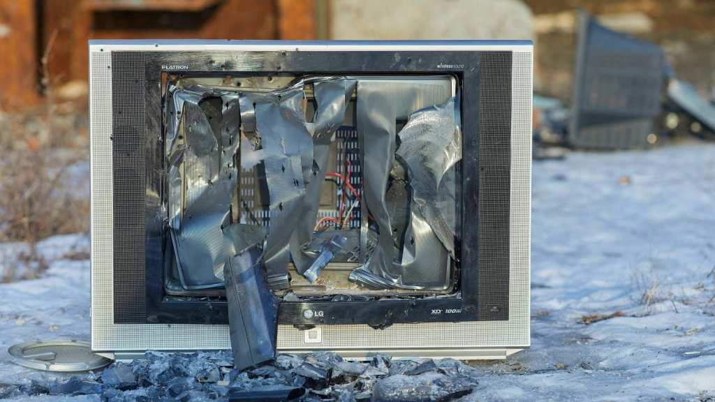 Television with busted screen sitting outside