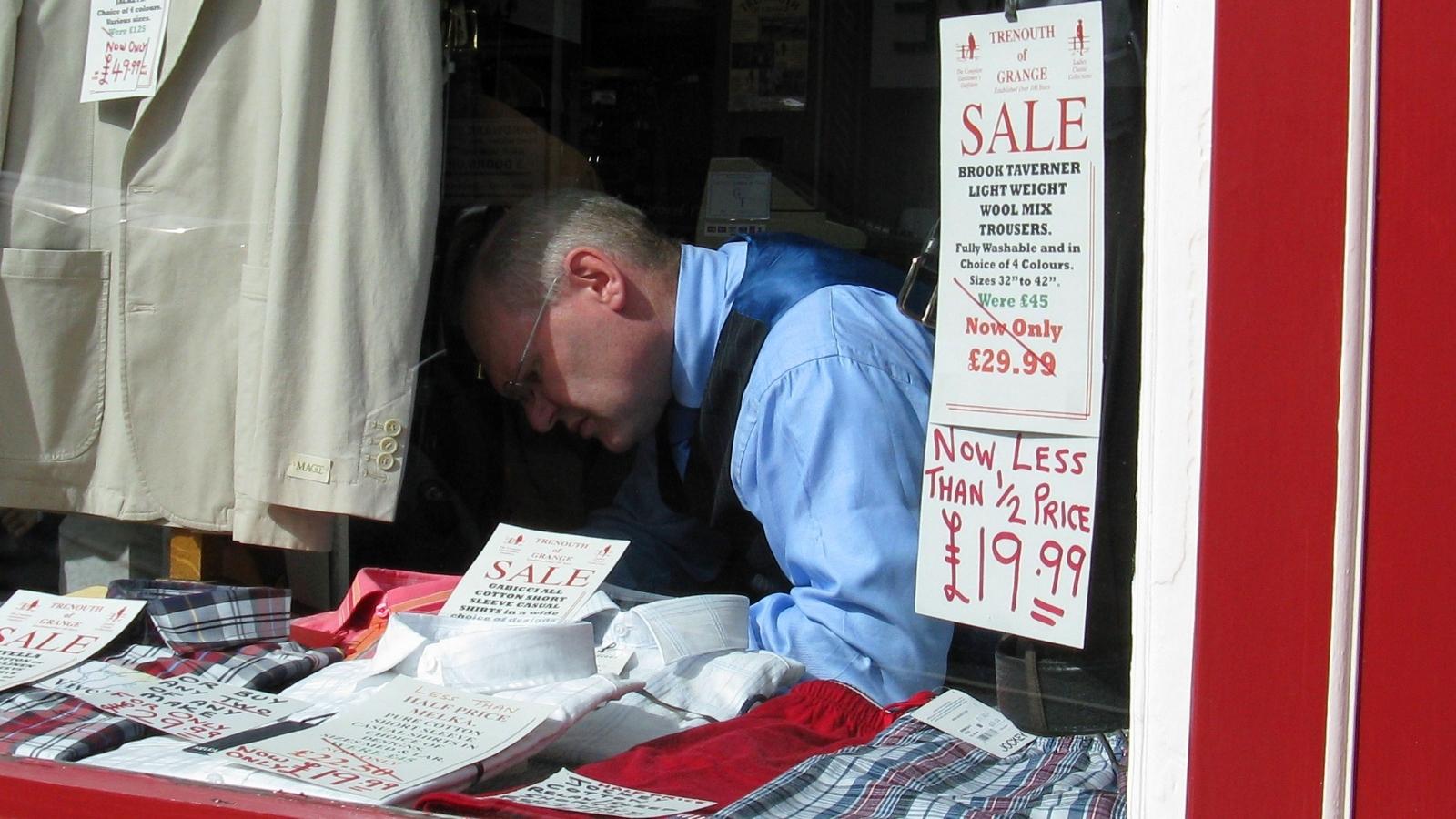 A Cashier Tried to Help an Entitled Customer Save Money—So They Used an Outdated Sign to Get Her Reported to Management Man changing sale sings in a window
