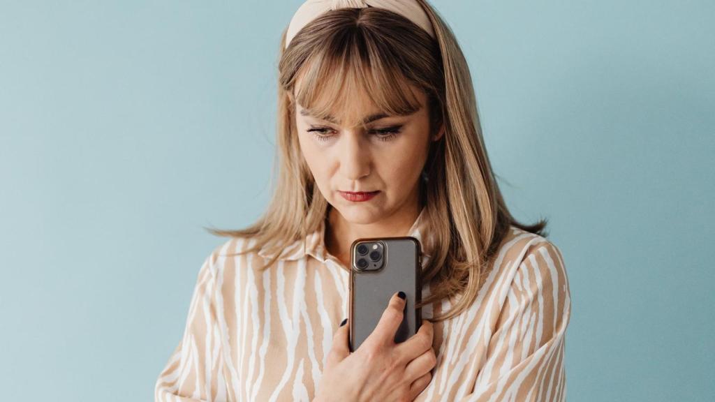 confused woman holding her smartphone
