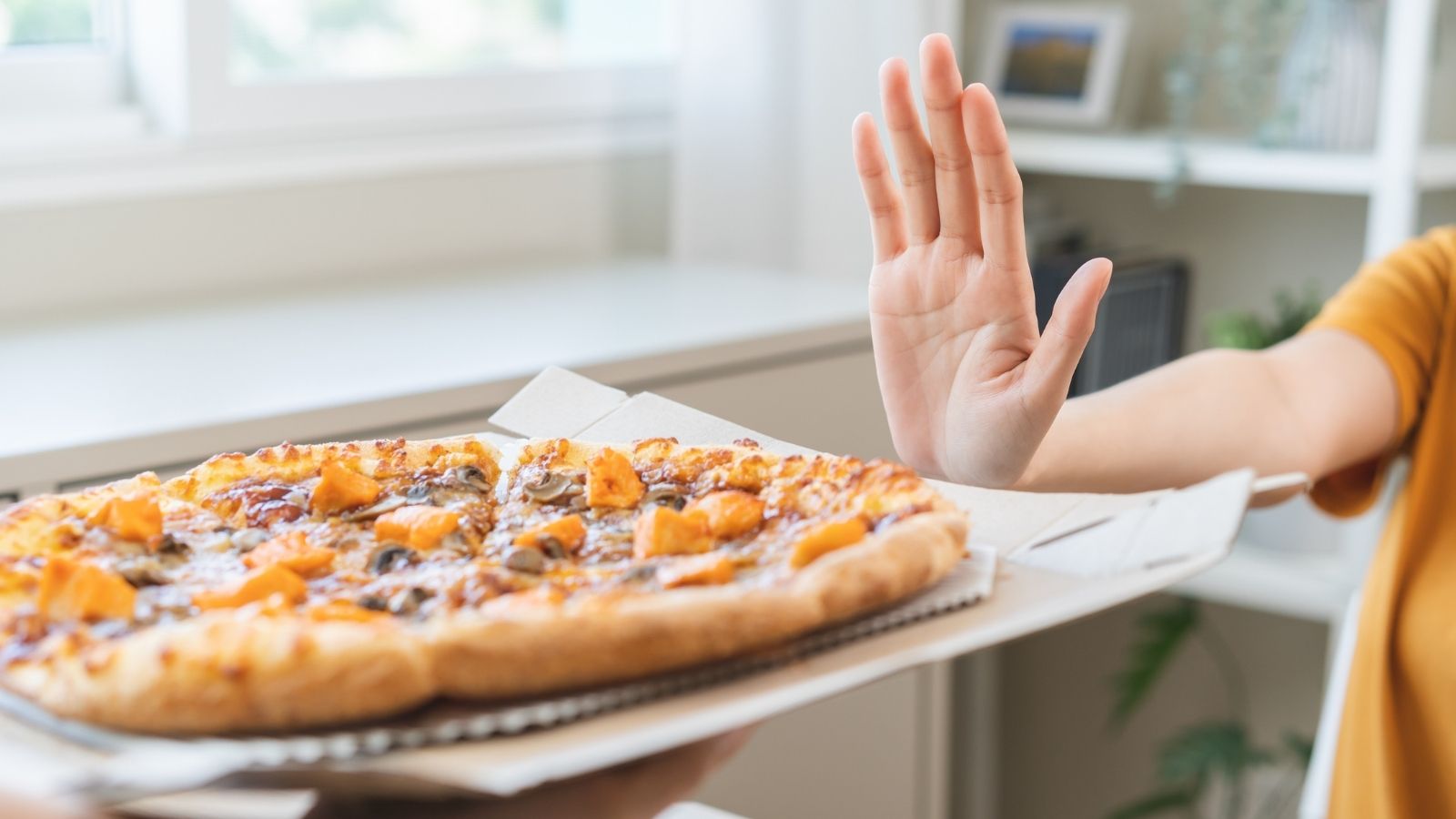Boss Picks Pizza Place for Team Bonding—Completely Ignores Employees Medical Condition woman's hand pushing away a pizza