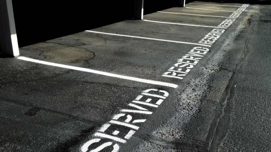 the word "reserved" written on parking spots