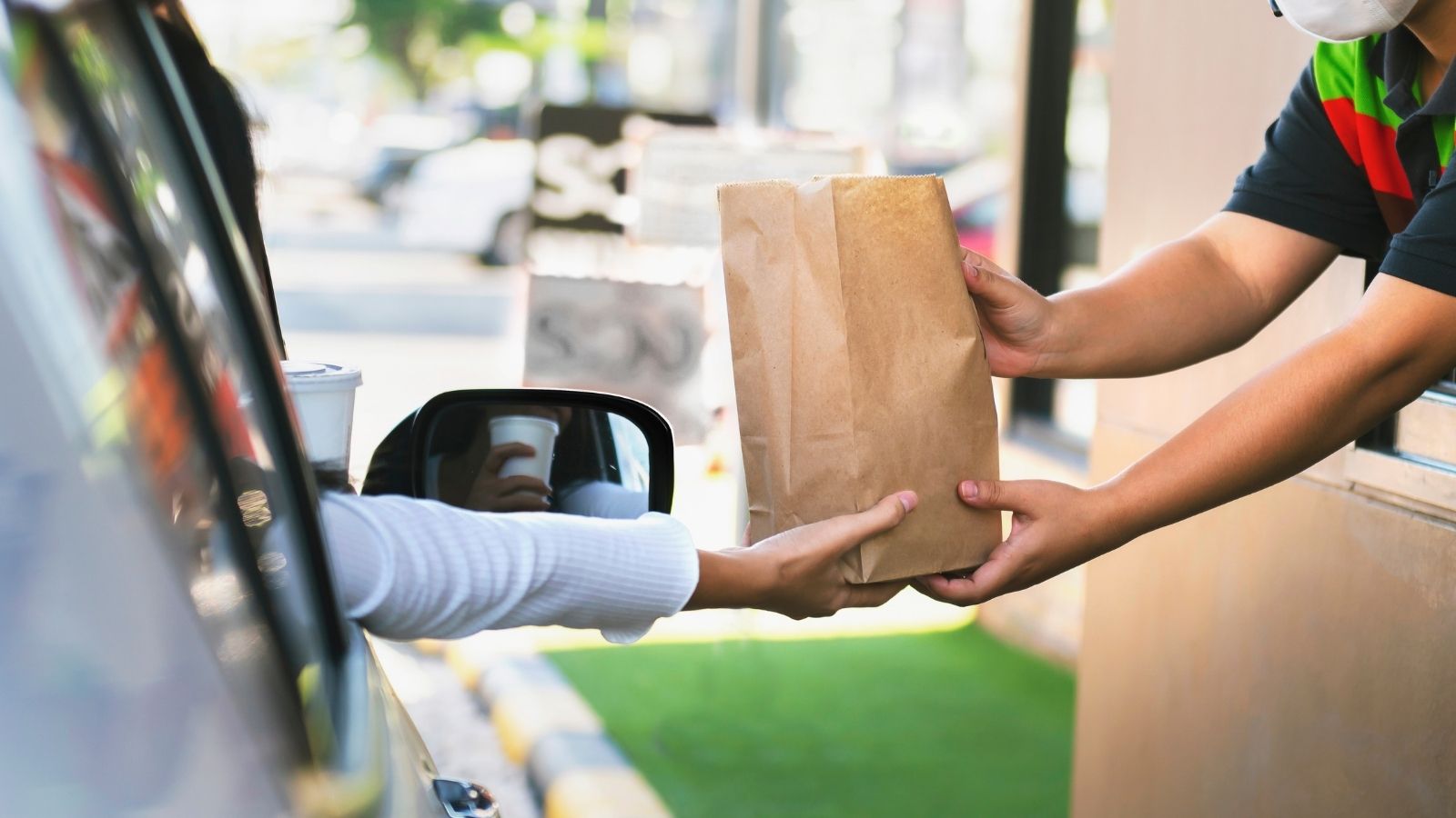 His Drive Thru Order Was Wrong — A Manager Came Out to Fix It — He Got Even More Upset employee handing customer their order at the drive thru